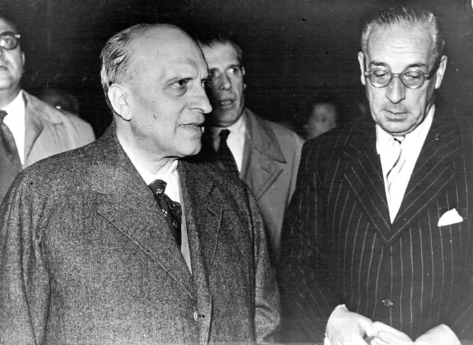Brussels Is The Scene -- The eyes of the diplomatic world are now centered Brussels, where the six-power conference on the European Defence Community begins today. This picture shows the Italian F.M., Signor Piccioni welcomed by the Italian Ambassador in ***** arrival at the airport. August 19, 1954.