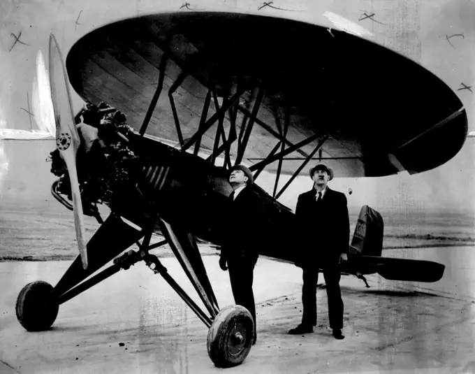 Two spectators studying the quaint round wings of the machine before the trial flight.The "Umbrella Plane" It has only wing, is designed to travel at 135 M.P.H, and can almost land in the backyard, say the inventors, two Chicago men. May 07, 1934. (Photo by Associated Press Photo).