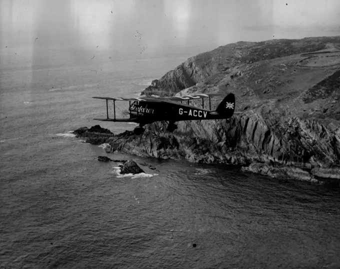 The Mollison Flight - Air Views as "Seafaber" Crosses Ireland -- The Seafarer passing Toe Head, Co. Cork.A series of Aerial views taken from an accompanying aeroplane, showing "Seafarer" with Mr. and Mrs. J.A. Mollison abroad, passing the Irish coast en route for a America, over the Atlantic. They succeeded in the crossing but unfortunately crashed at Bridgeport Connecticut. Both are now in Hospital. July 25, 1933. (Photo by Associated Press Photo).