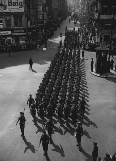 Guards in Army Day March -- A detachment of Welsh Guards marches down fleet street, London during an army day parade today may 5. More than 2,000 troops marched through the city in the biggest military parade since Ve Day. It was mostly a Khaki Parade, but kilts, Bagpipes and Brightly polished brasses brought touches of colour to the ceremony. Most of the soldiers taking part were young men of between 21 and 23, called up since the war. The Lord Mayor London, Sir George Aylwen took the salute of the parade as it passed St. Paul's Cathedral. May 05, 1949. (Photo by Associated Press Photo).