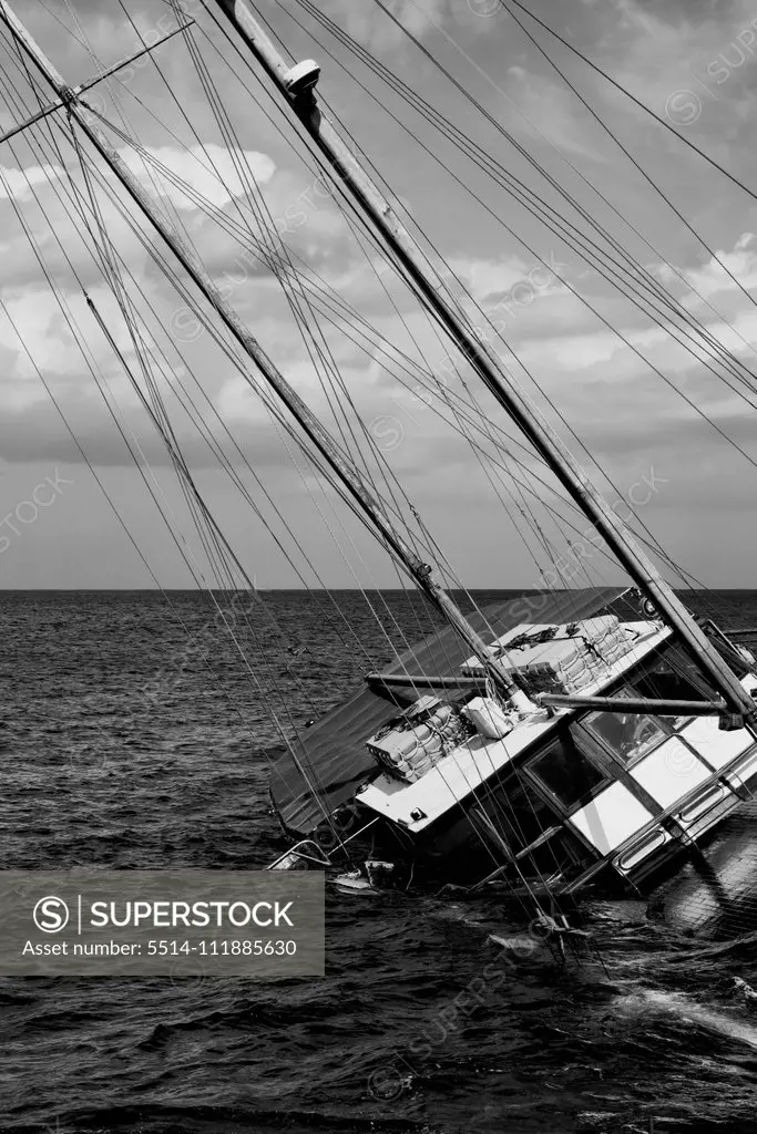 Shipwrecked Schooner sinking near coastal rocks