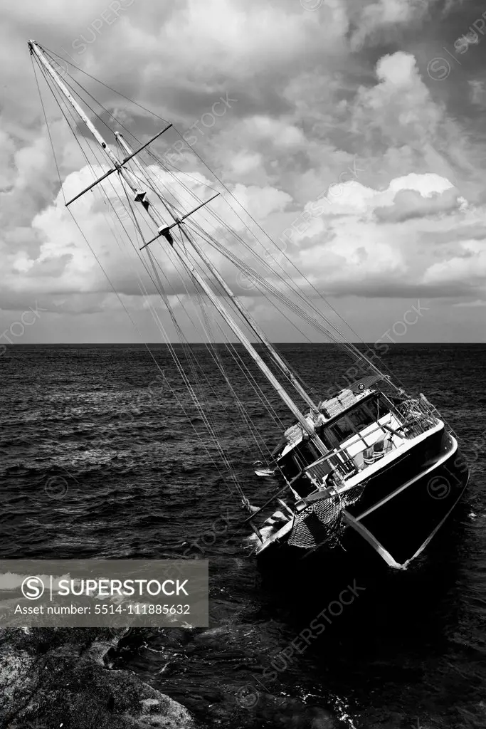 Shipwrecked Schooner sinking near coastal rocks