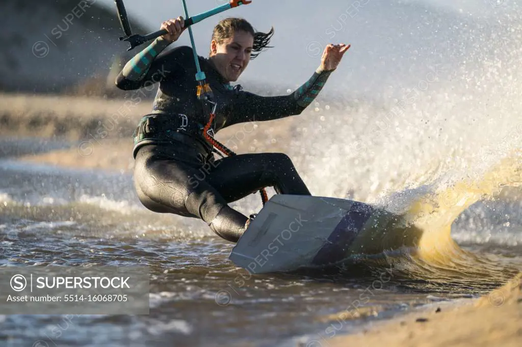 Action shot of an excited female athlete kiteboarding in Mexico