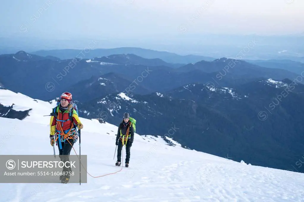 A female mountaineer looks up determinedly at the summit of Mt. Baker