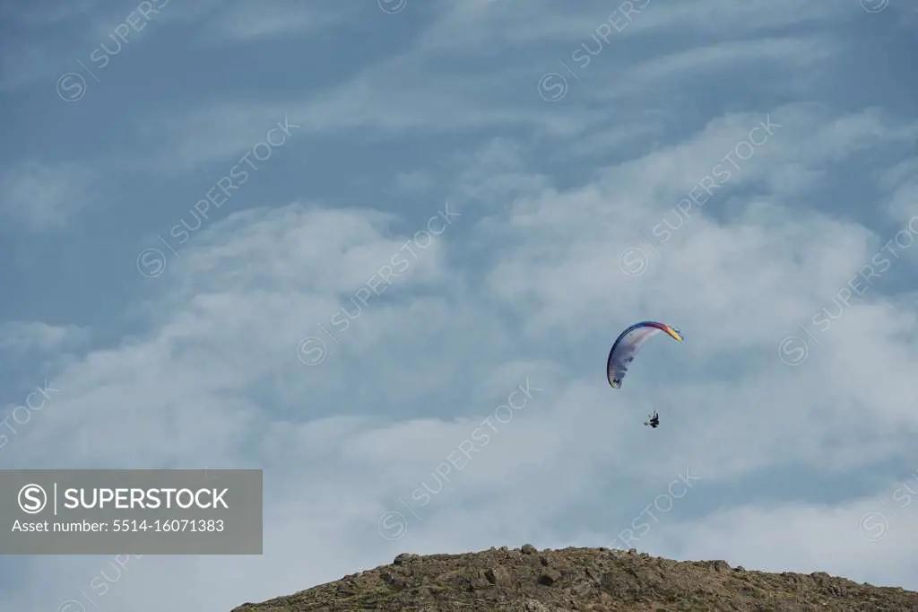 Skydiver flying in blue sky in sunny day