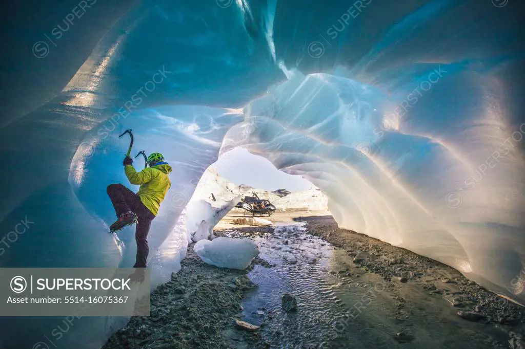 Man ice climbing in cave during luxury adventure tour.