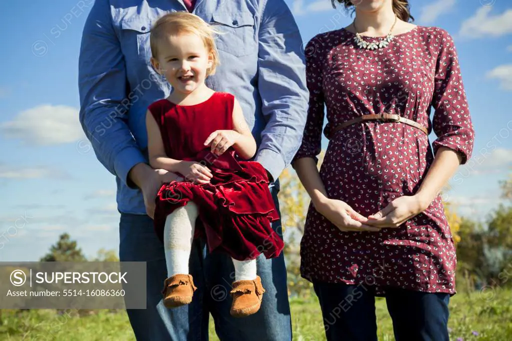 Young pregnant couple holding daughter in Detroit MI