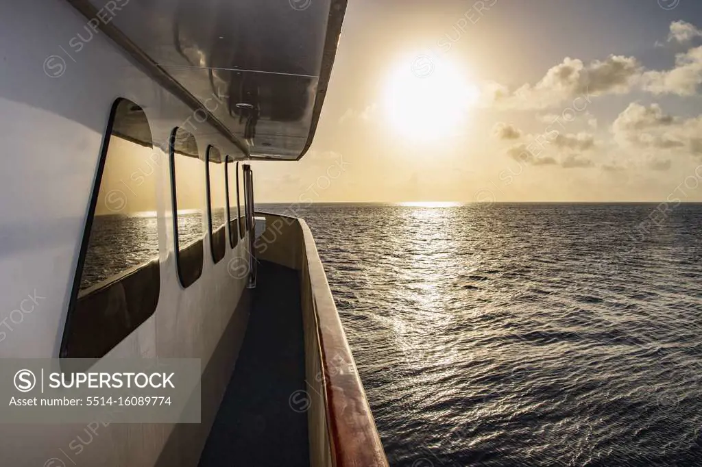 passenger vessel heading into the setting sun