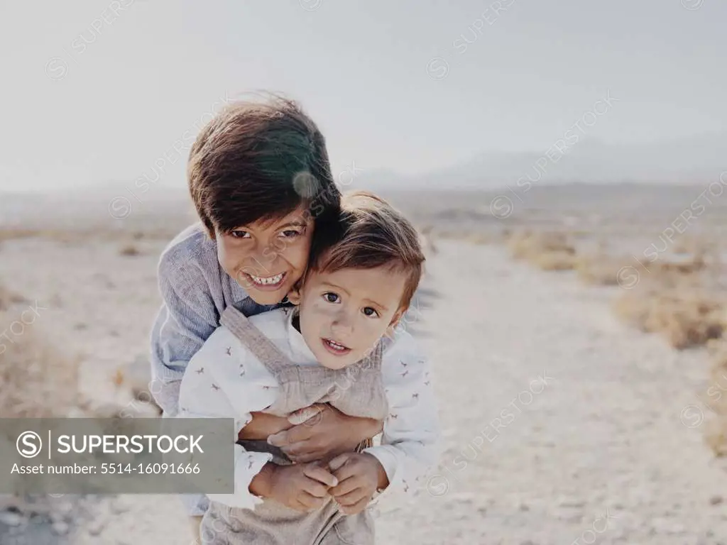 Portrait of two kids hugging in the desert