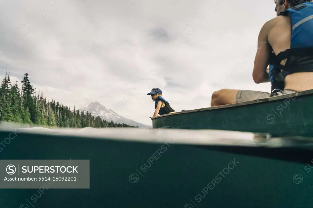 A young girl rides in a canoe with her dad on Lost Lake in Oregon.