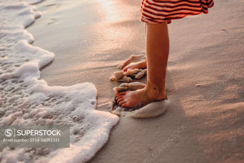 Burying her toes in the sand on the beach at Pensacola, Florida