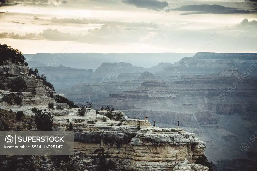 people over cliffs rocks in grand Canyon