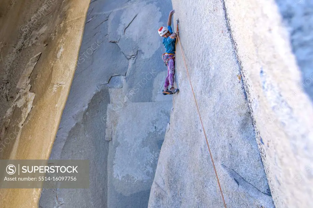 Rock climber looking down while climbing on big wall in Yosemite