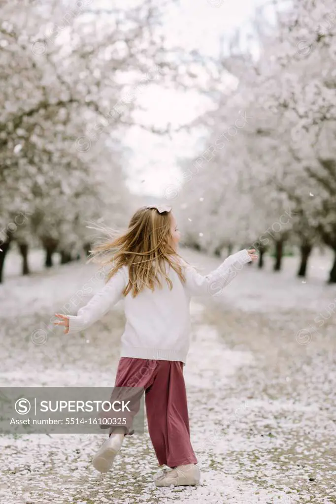 Preschool girl dancing in an almond orchard