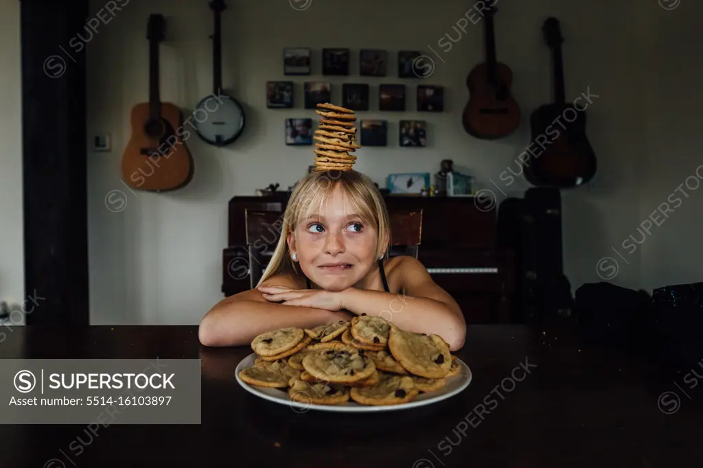 Young girl balancing cookies on her head