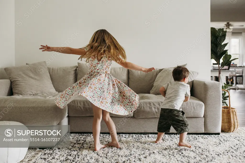 Siblings Twirling in Living Room