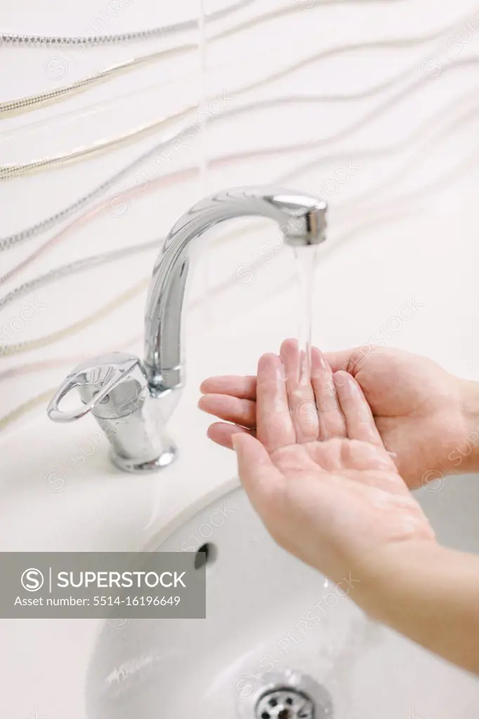 Woman washes her hands by surgical hand washing method. She washes his