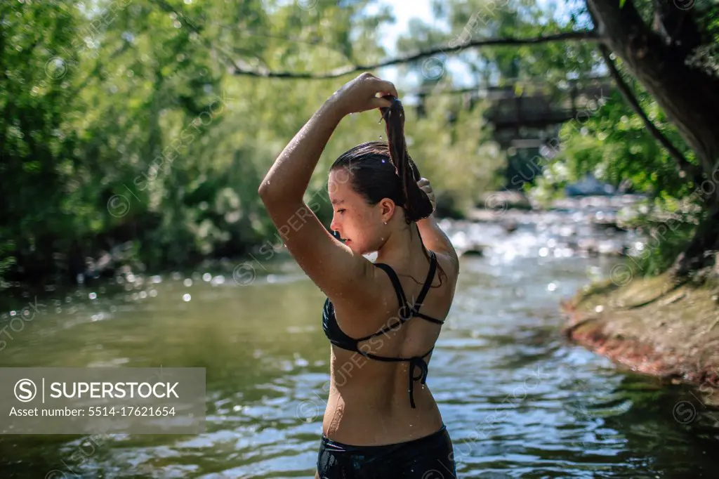 Portrait of teen girl playing with wet hair on a summer day