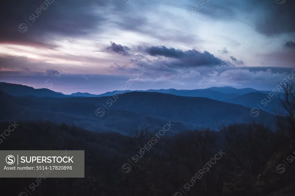 dramatic pink and purple clouds over smokey mountains at sunrise