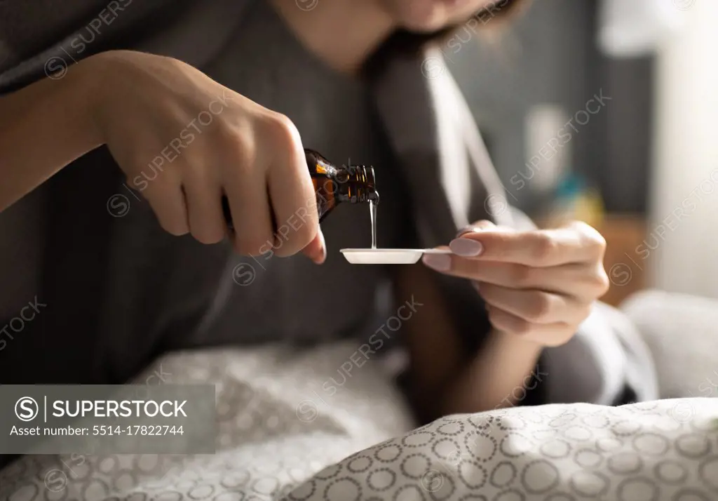 Crop female pouring syrup in spoon