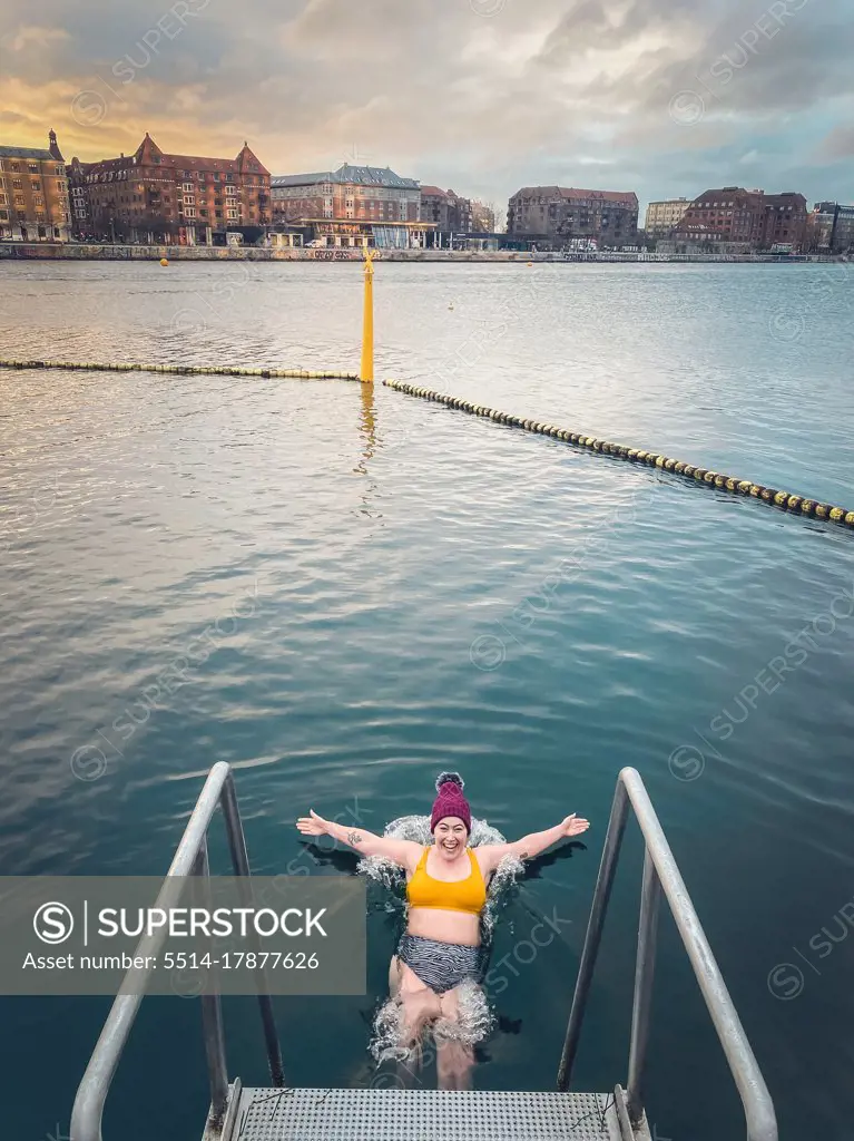 Young Woman At Sunrise Gracefully Falling Into Freezing Water Denmark