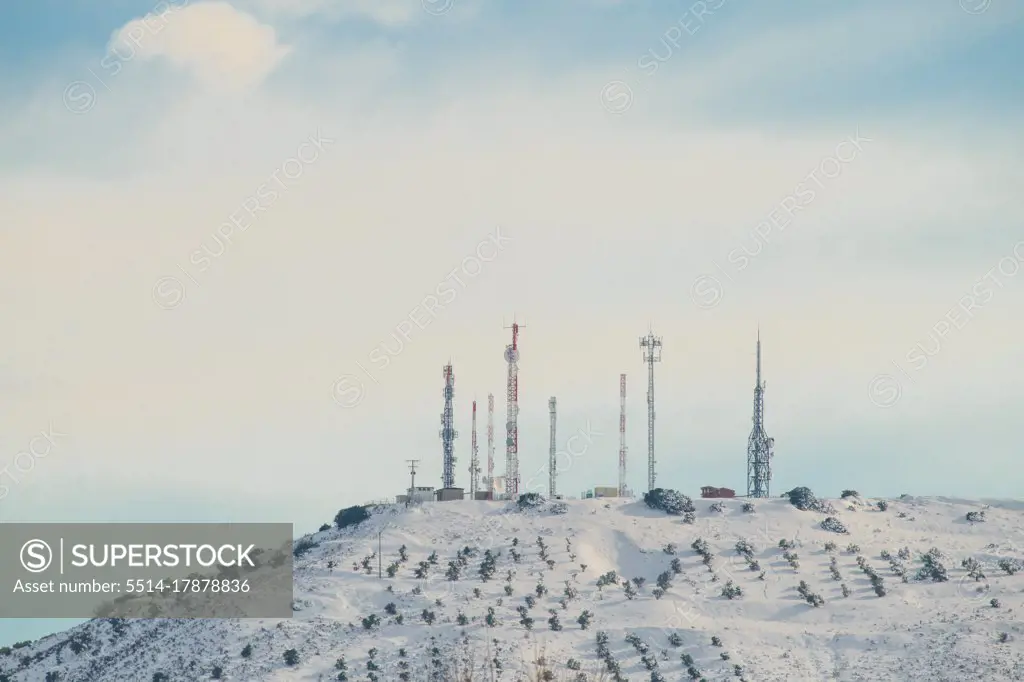 Group of telecommunications antennas on snowy mountain