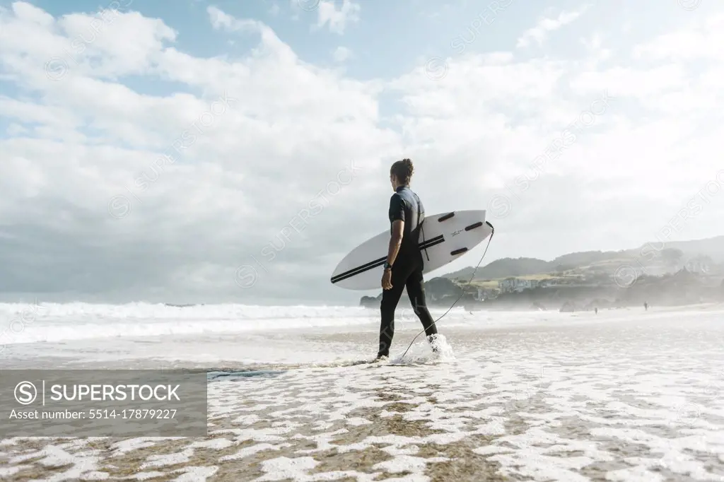 Surfer entering the water in the Basque country, Spain, Bilbao