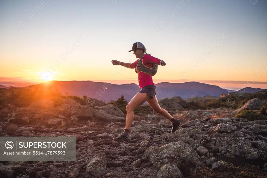 Woman running in the White Mountains at sunrise in summer