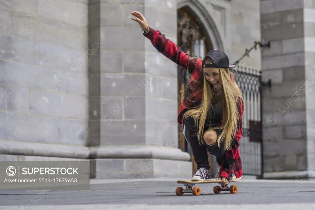 Female skateboarder balancing herself on skateboard rolling arou