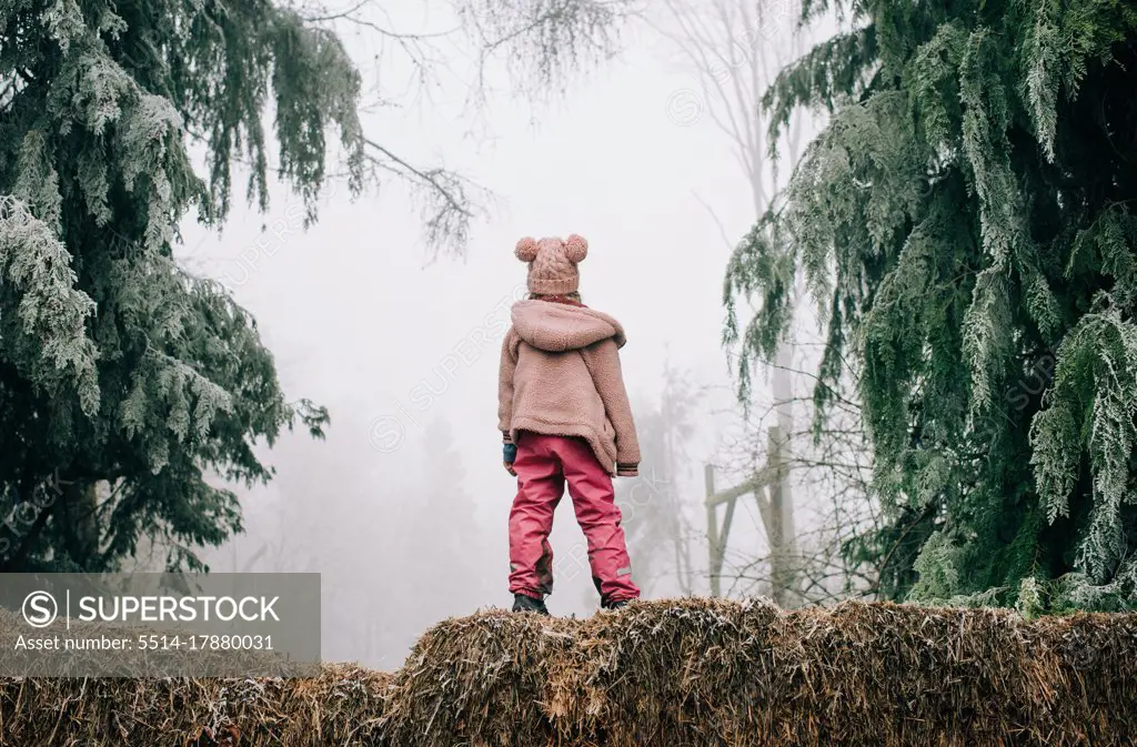 girl stood in the frosty forest looking into the fog in England