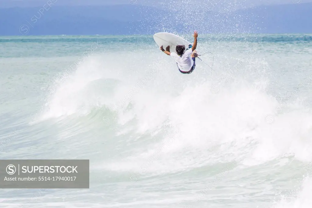 Surfer jumping on wave in mid air