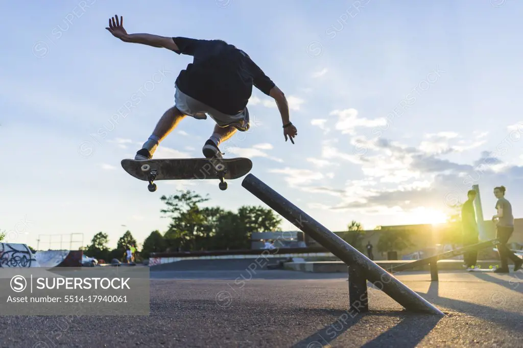 Athletic teenage skateboarder doing a grind