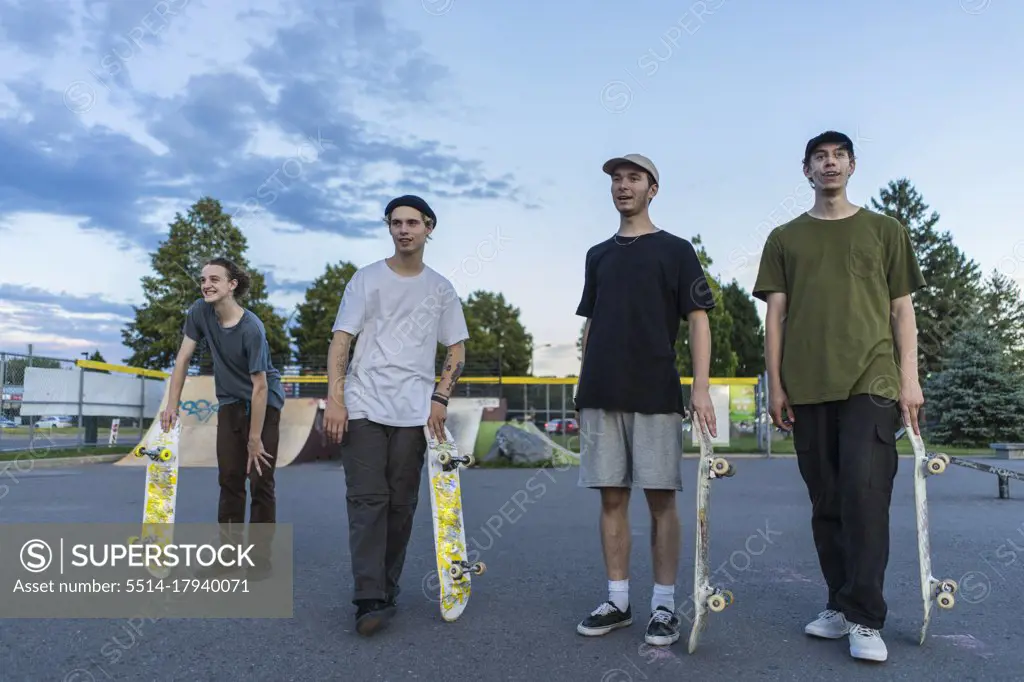 Group of athletic teenage skateboarders in skatepark