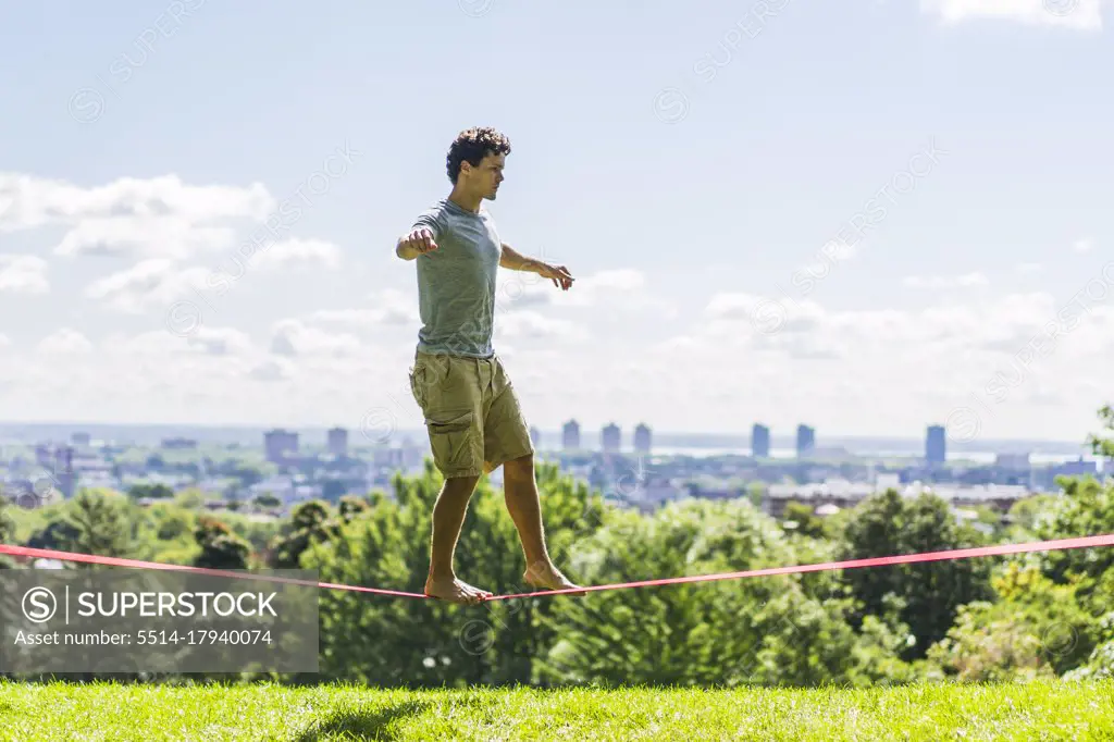 Athletic man attempting to slackline