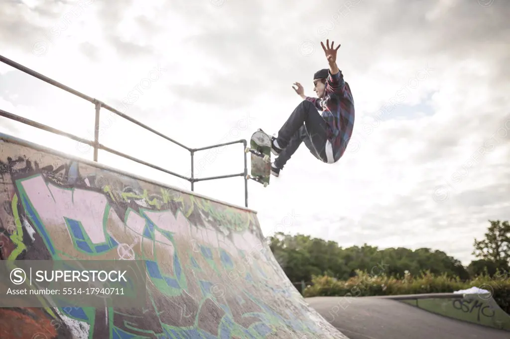 Skateboarder skateboarding in skatepark on ramp