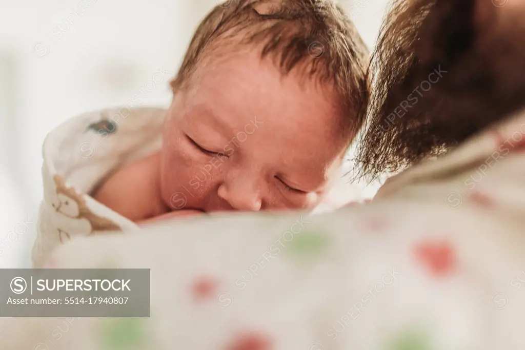 Close up of newborn face resting on new dad