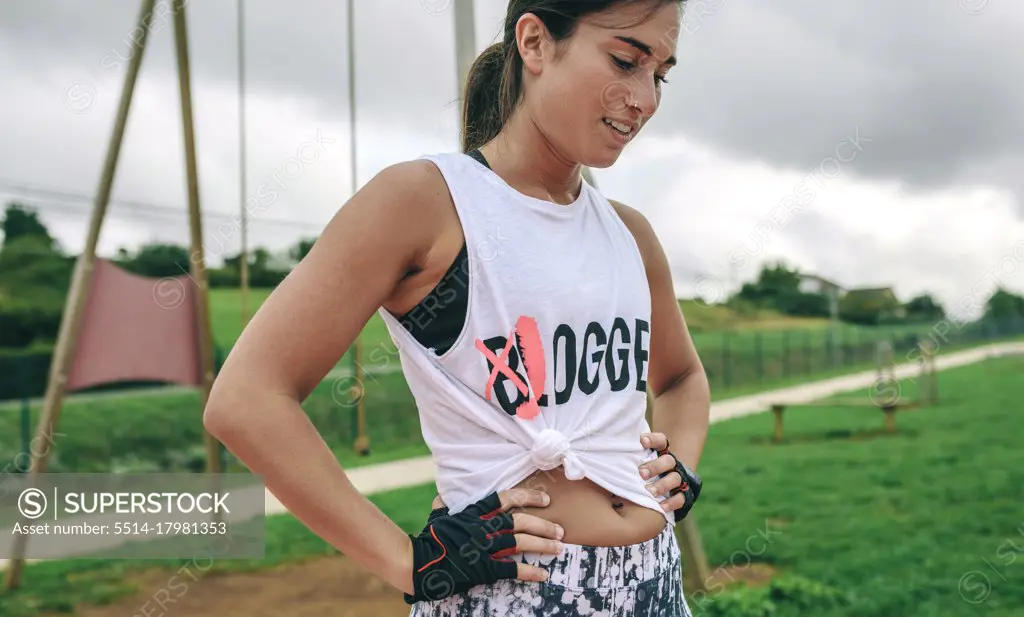 Tired female athlete with knotted shirt