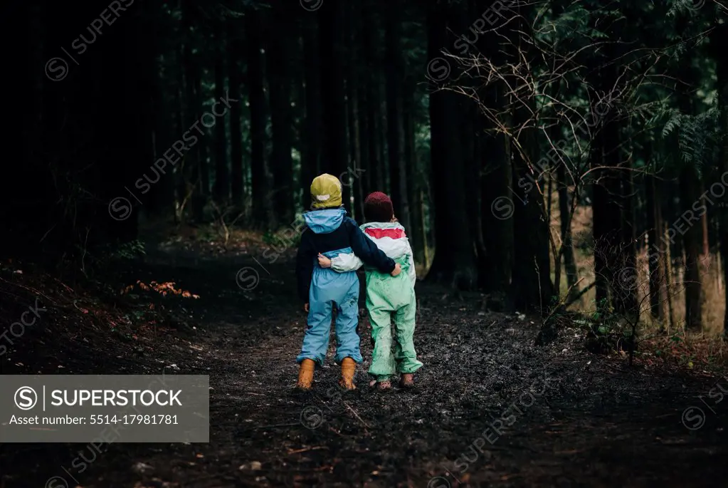 siblings hugging each other walking along the forest talking