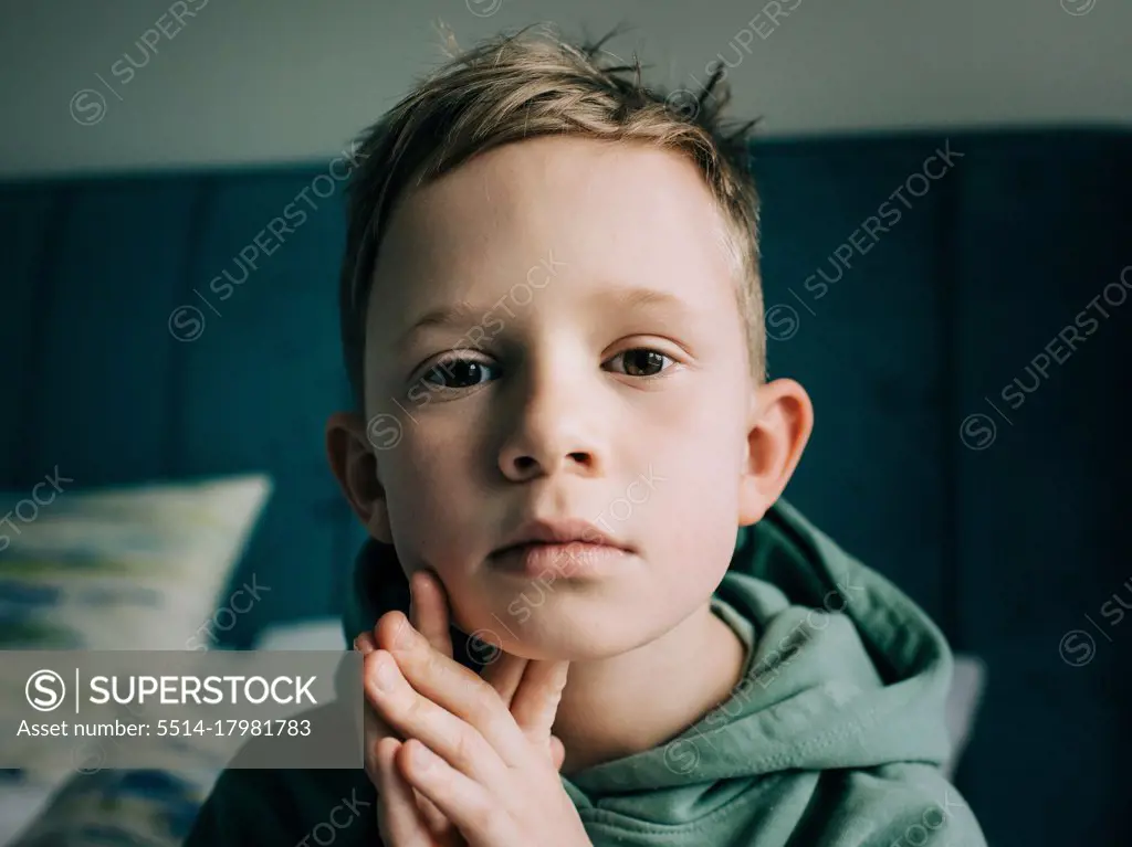 close up portrait of a 8 year old handsome blonde boy starring