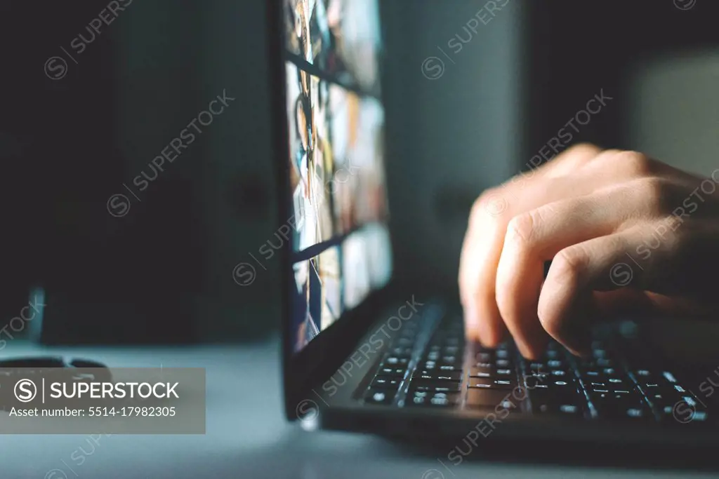 Anonymous woman working on laptop at night