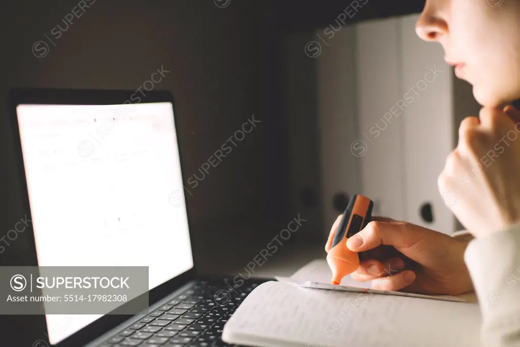 Anonymous woman working on laptop at night