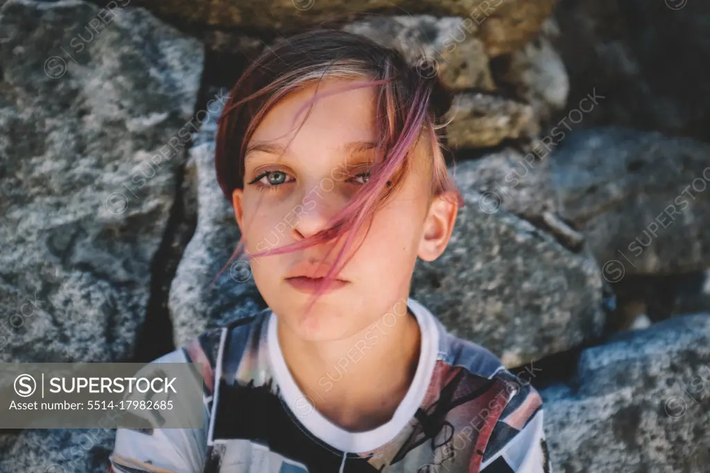 Boy With Pink Hair and Graphic Shirt Looks into the Camera