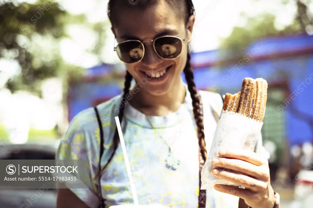 Smiling alternative hipster with churros outside Fridas House Mexico