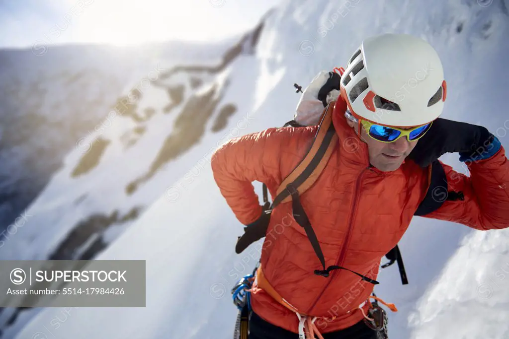 Ice Climber fixing his pack before ice climbing