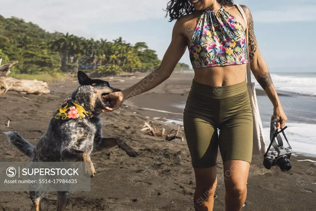 Woman playing with her dog on the beach.