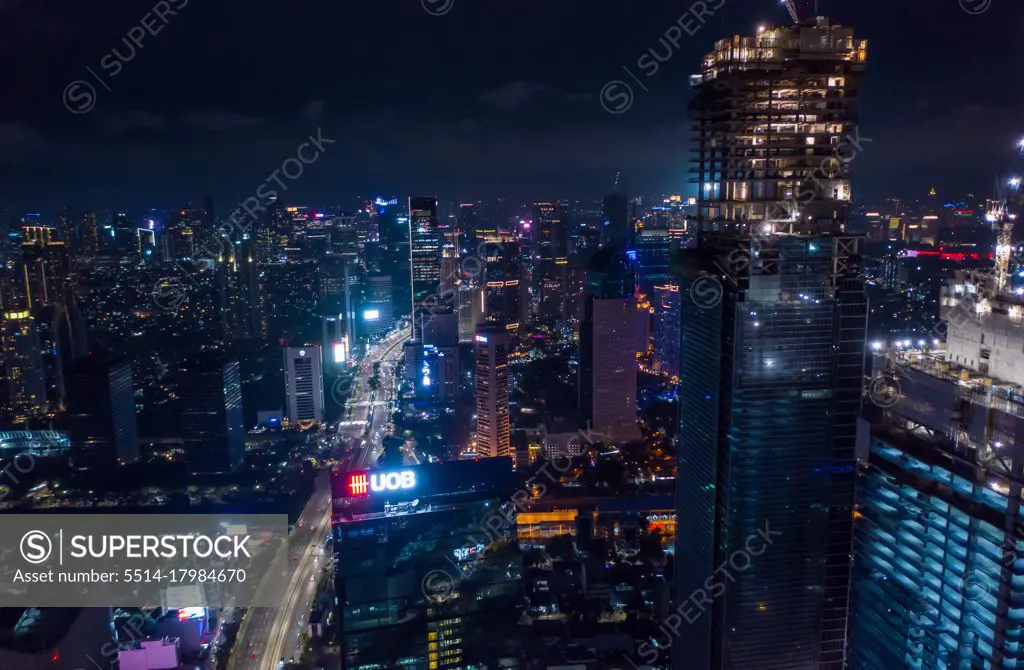 Close up aerial view of high rise skyscraper under construction in modern city center at night Tall skyscrapers in downtown Jakarta, Indonesia