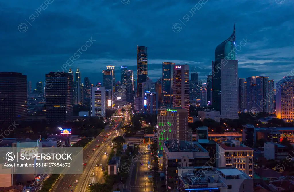 Night aerial wide view of skyscrapers and multi lane highway in large urban city center Cityscape of high rise buildings in Jakarta, Indonesia at night