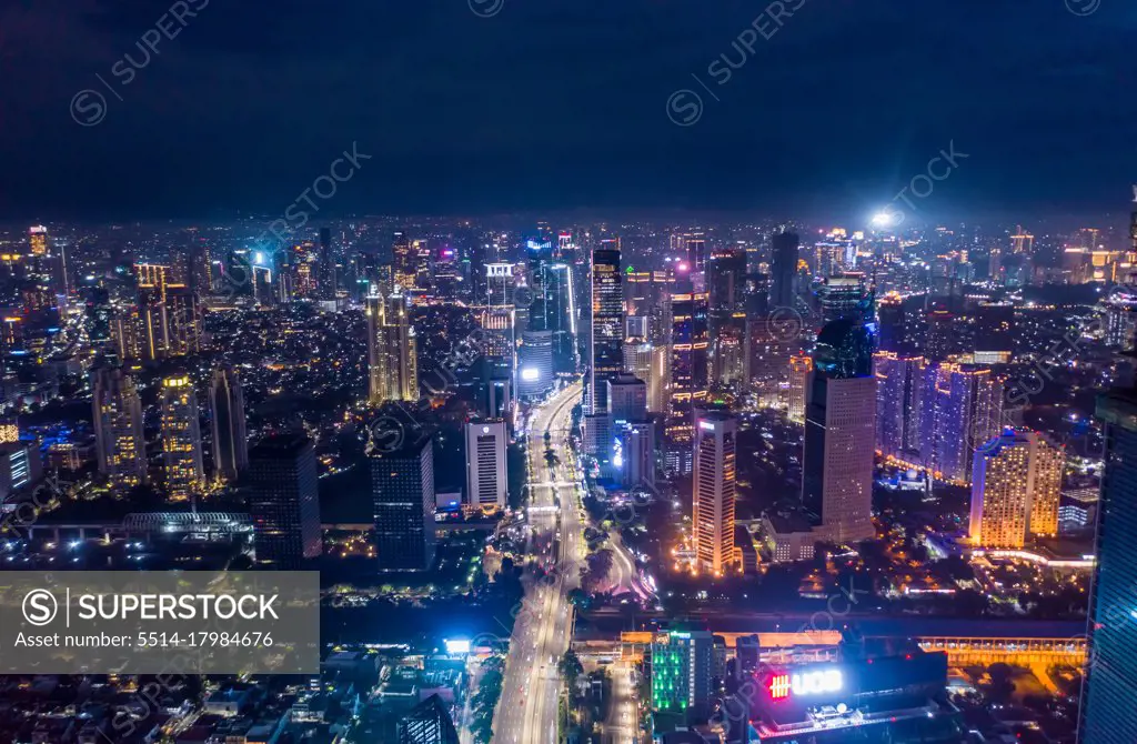 Aerial night cityscape of skyscrapers and multi lane highway traffic in modern city center of Jakarta, Indonesia Urban city center with high rise buildings at night