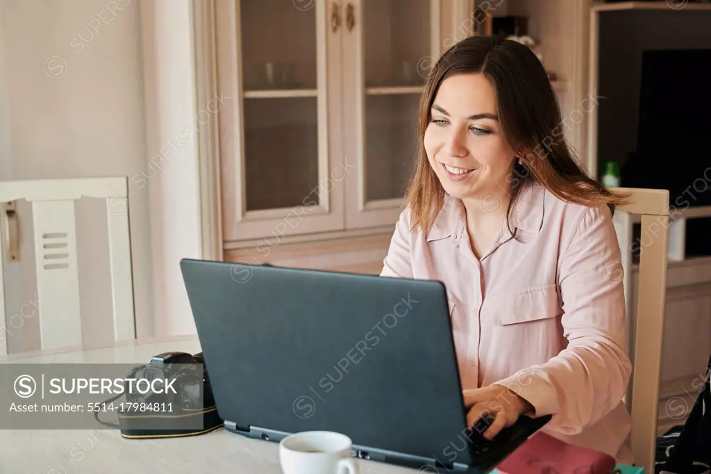 Young woman works from home on her laptop