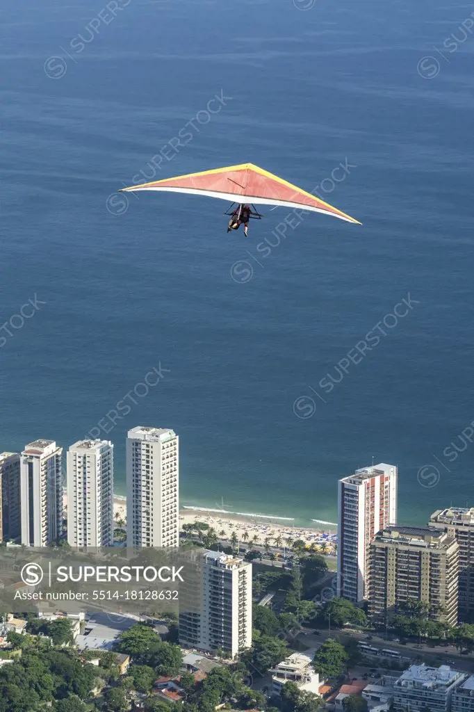 Beautiful view to hang glider flying over blue ocean and buildings